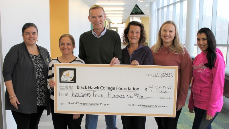 6 people standing with oversized check