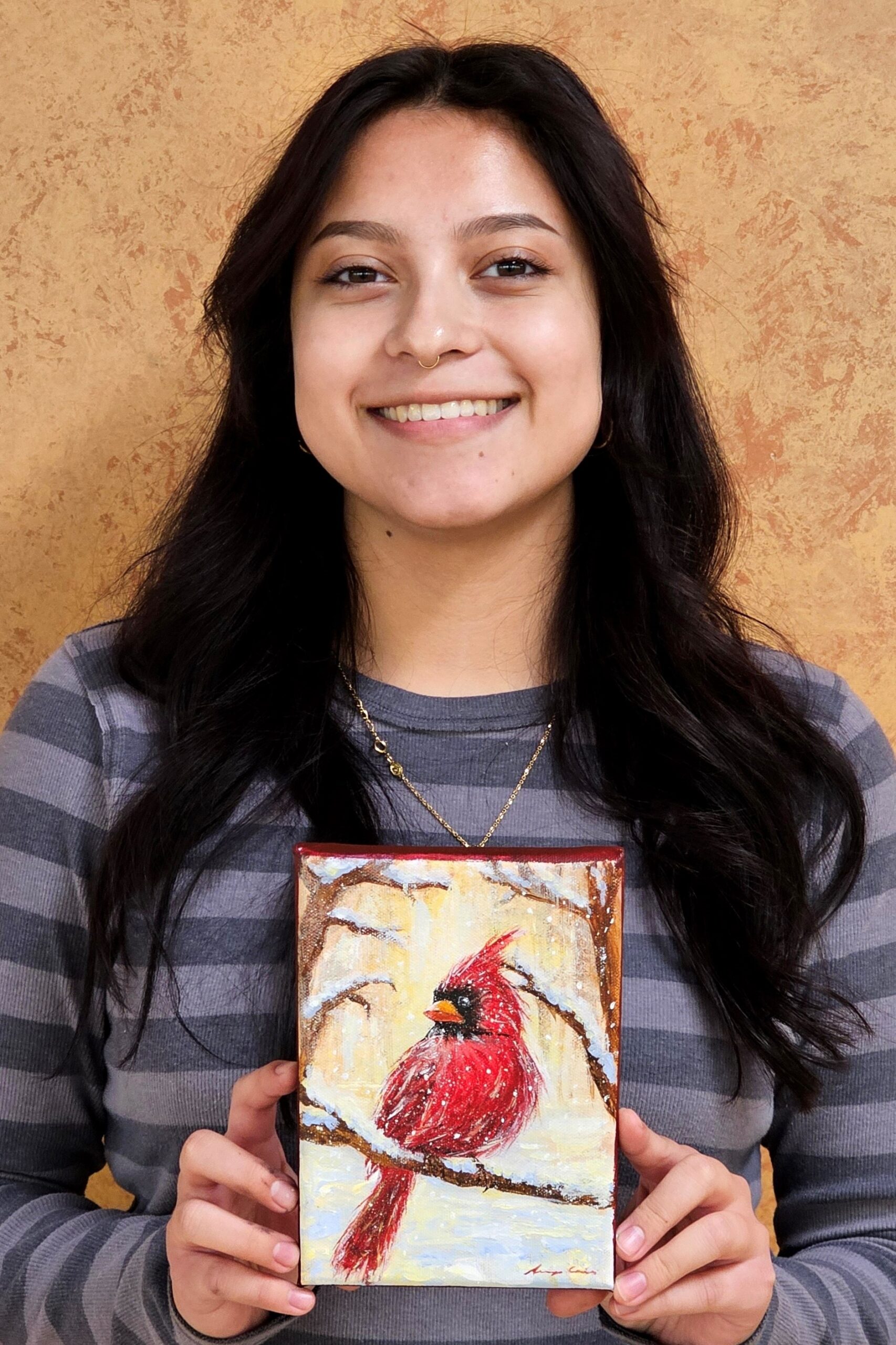 smiling student looking at camera and holding holiday card