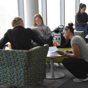 Students sitting around small table in the library