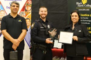 2 people presenting award to a police officer