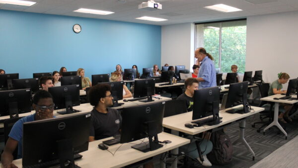 a group of people in a room with computers