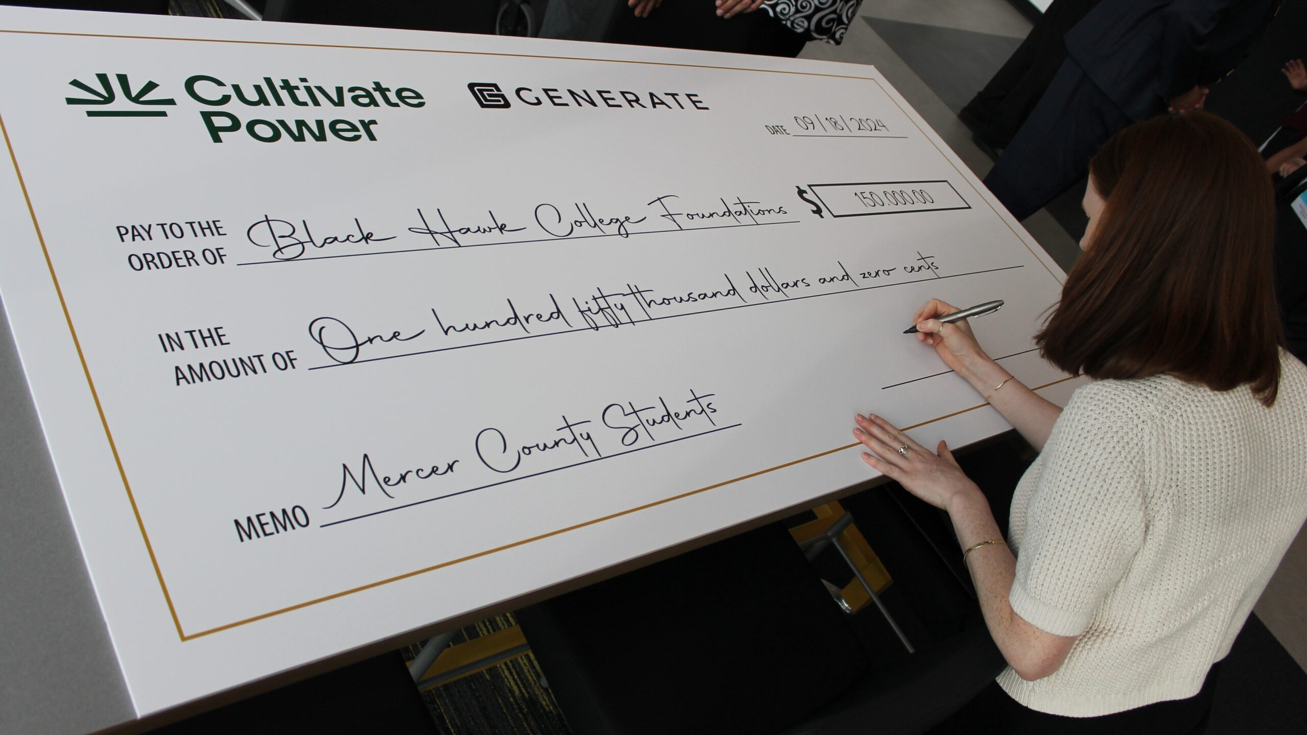 woman signing oversized check