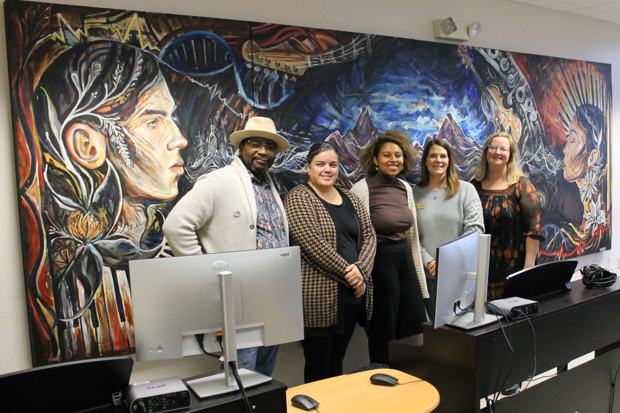 5 people standing in front of mural in electronic music classroom