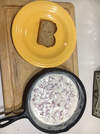 toasted piece of bread on plate next to chipped beef mixer in pan next to it.