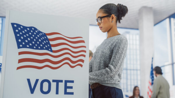 Young Black Woman at a voting booth.