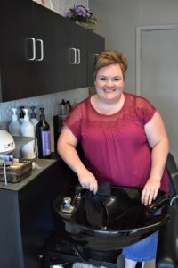 woman standing behind a shampoo sink