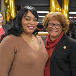 graduate and her mom smile while wearing nursing pins