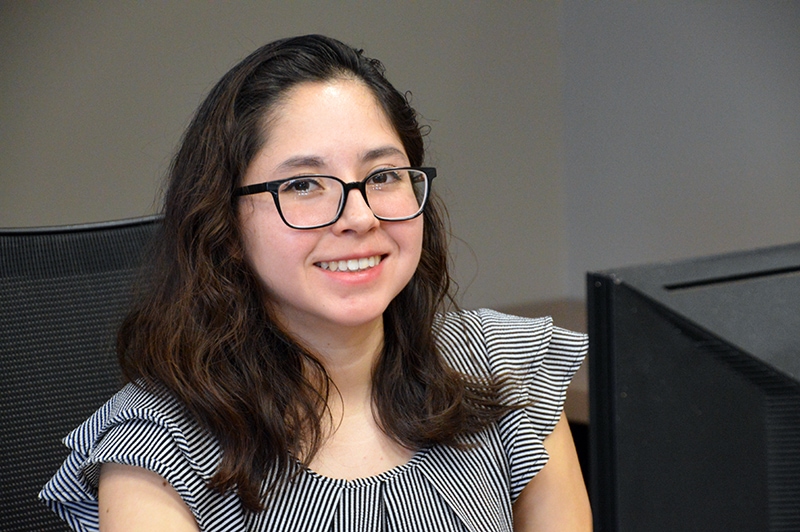 smiling female student sitting in front of a computer