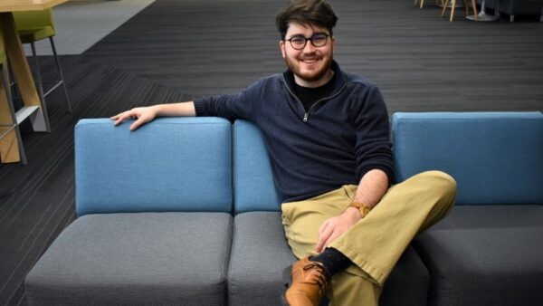 man sitting on couch in a lobby at Black Hawk College