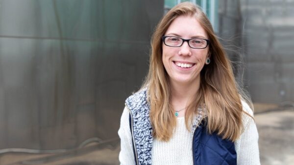 smiling student standing outside of a building