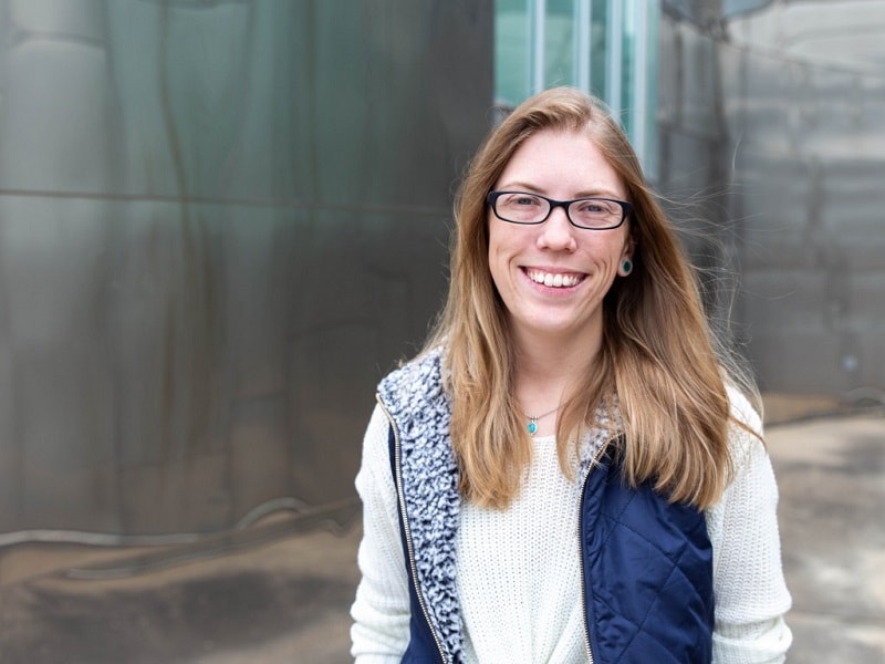 smiling student standing outside of a building