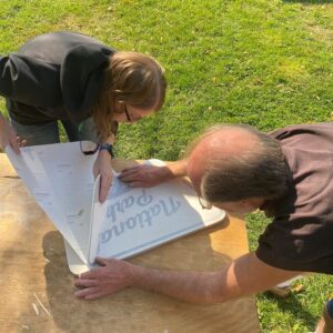 two people working on a sign that reads National Park