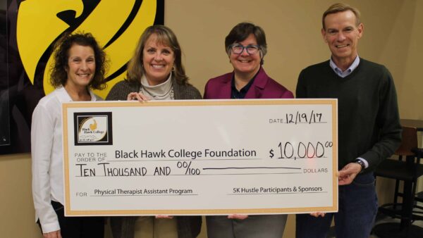 3 women and 1 man holding oversized check