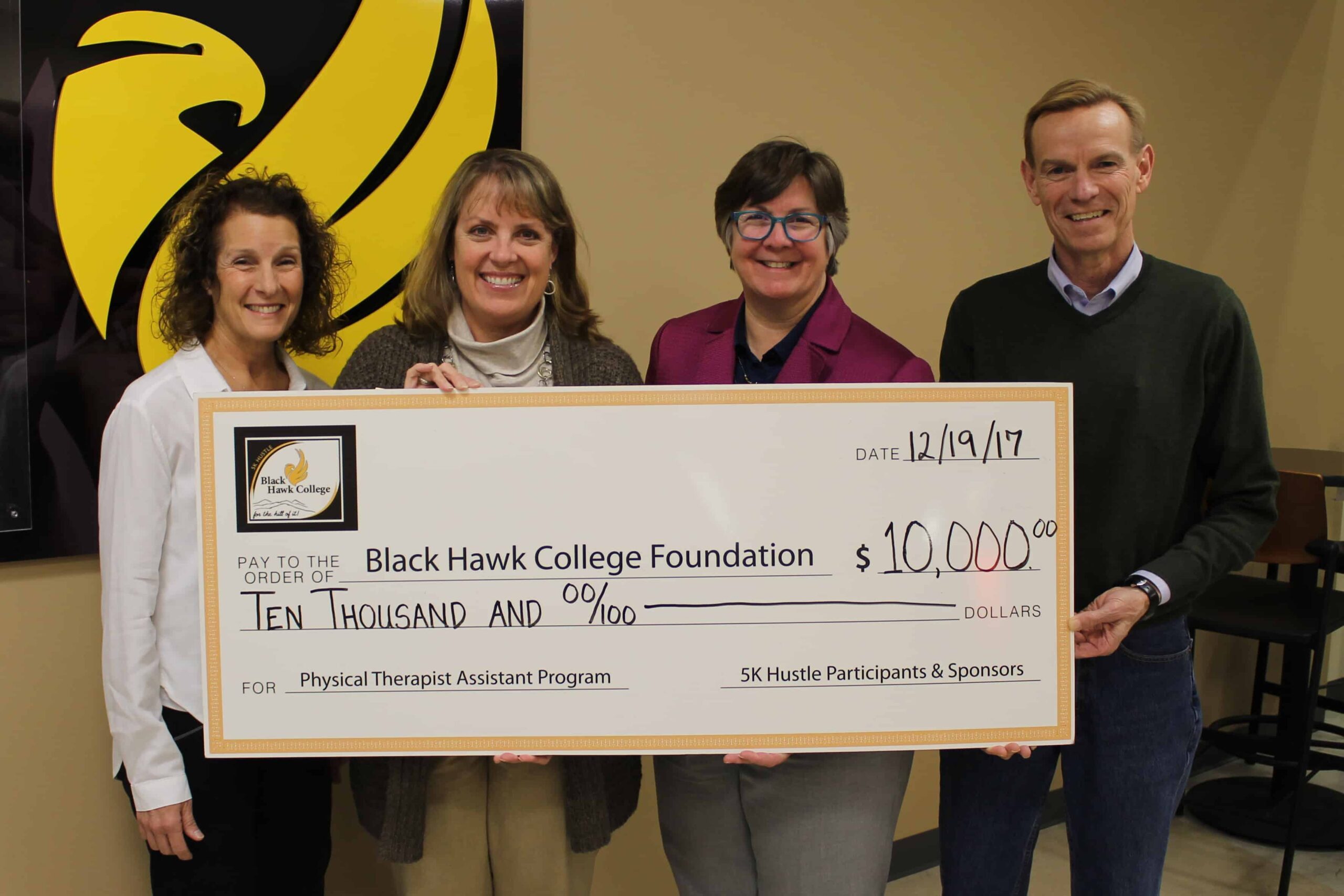 3 women and 1 man holding oversized check