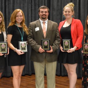 Students holding plaques