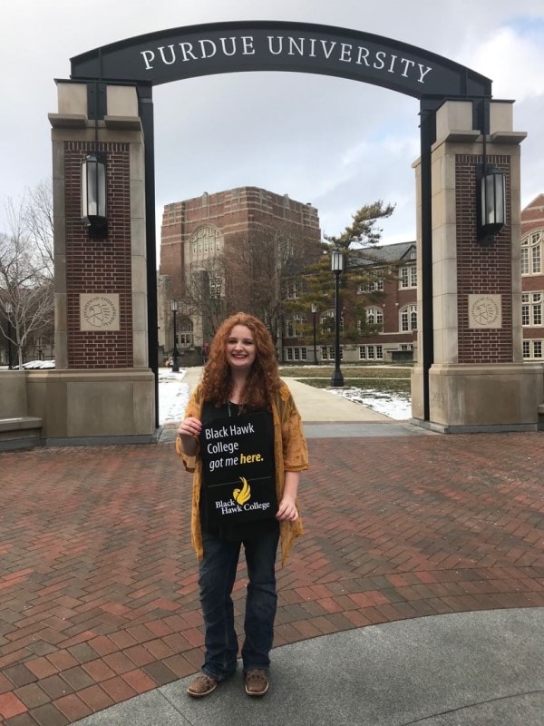 student holding a sign that says Black Hawk College got me here