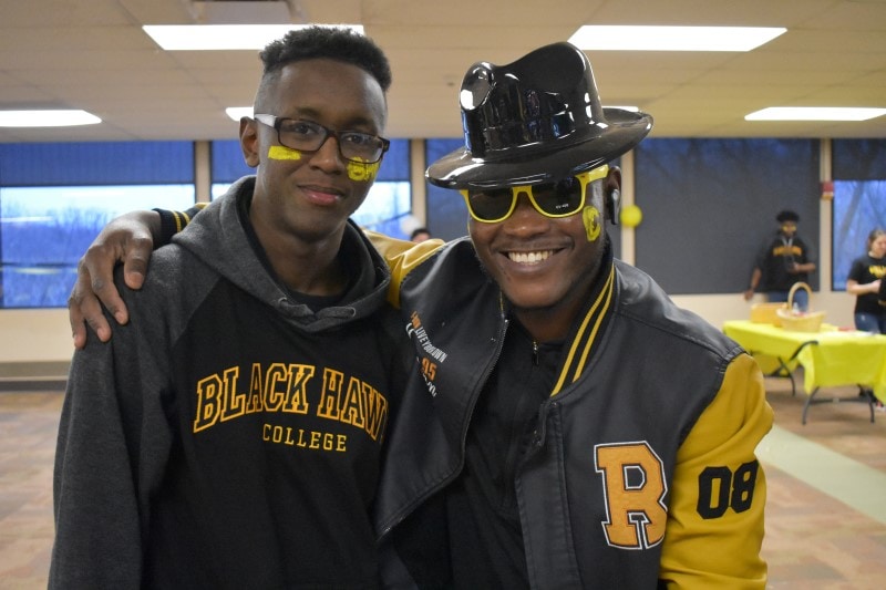 two students wearing black and gold for a Black Hawk College spirit event