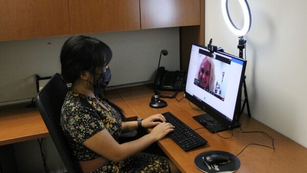 woman sitting at a desk using a computer to try out the interview equipment at Careers Services