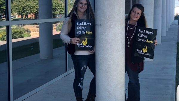 Transfer students holding signs saying Black Hawk College got me here