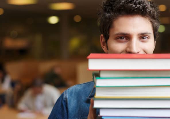 Male student with stack of books