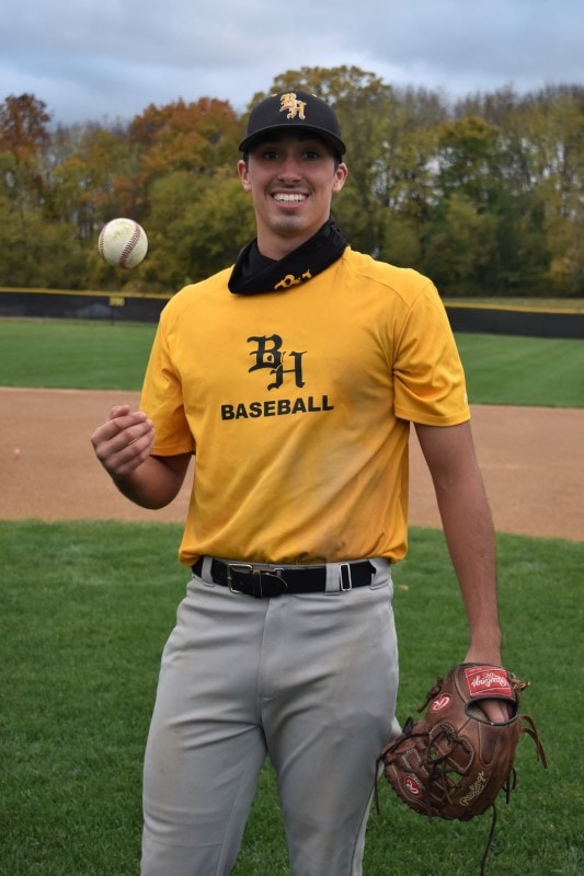 baseball player tosses a ball in the Black Hawk College field