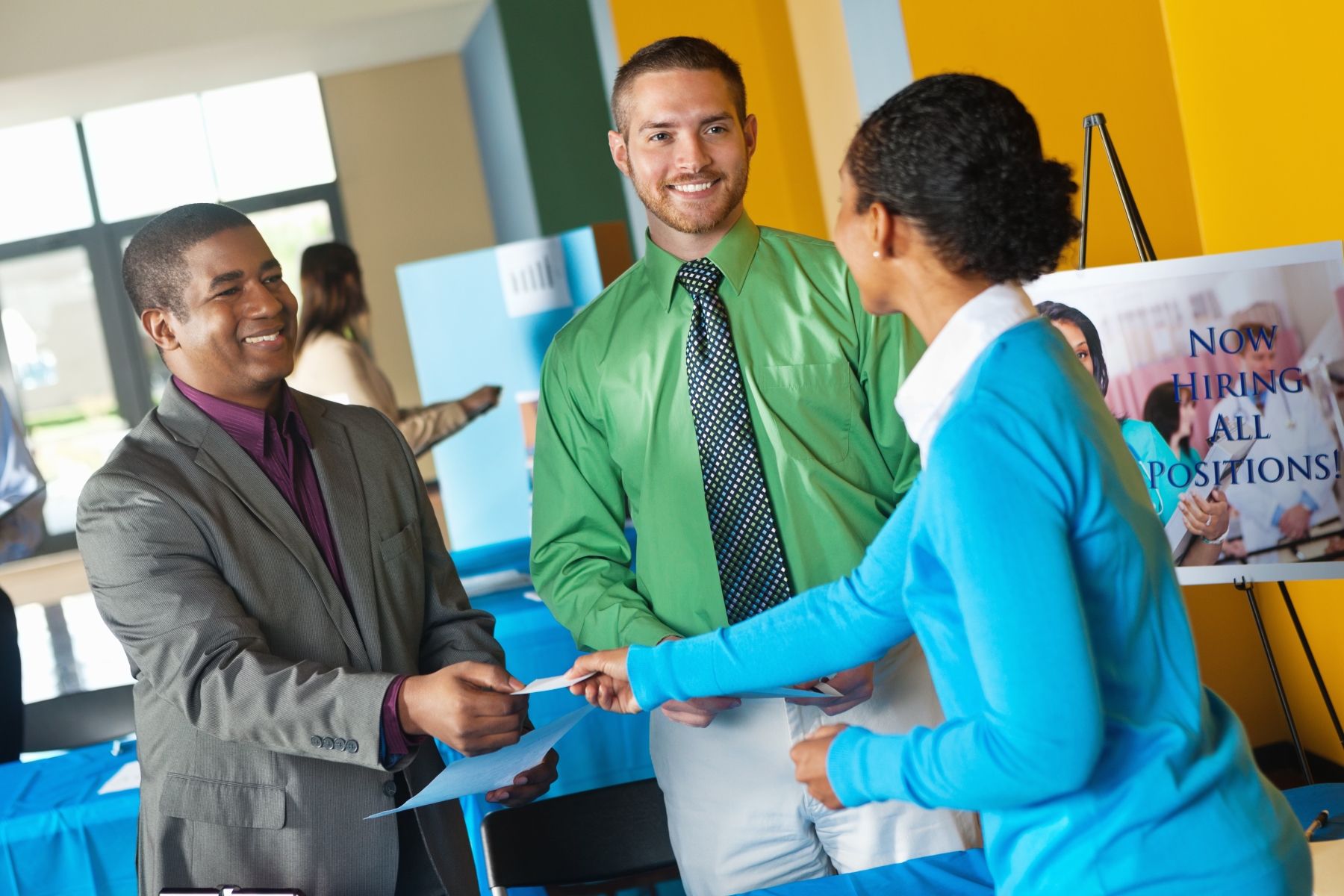 3 people exchanging business cards at career fair