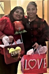 2 people smiling & holding Valentine's Day gifts