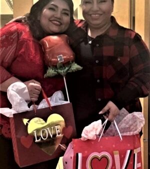 2 people smiling & holding Valentine's Day gifts