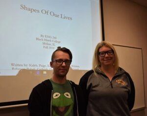 Course instructor and guest in front of classroom screen