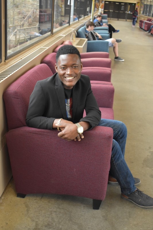 student sitting in a chair in a hallway