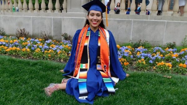 smiling graduate wearing her cap and gown