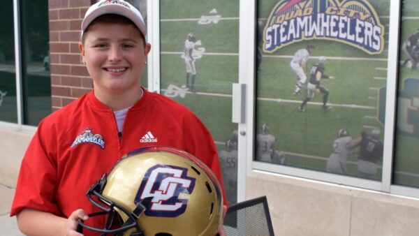 woman holding a football outside of the Quad City Steamwheelers office