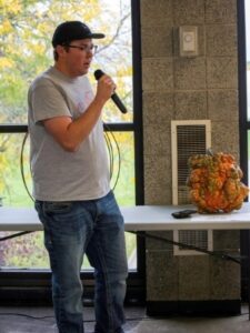 livestock judging team member with microphone in front of pumpkin on table