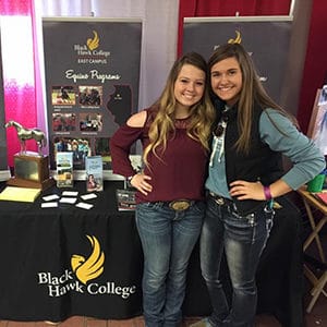 Two girls standing in front of a table