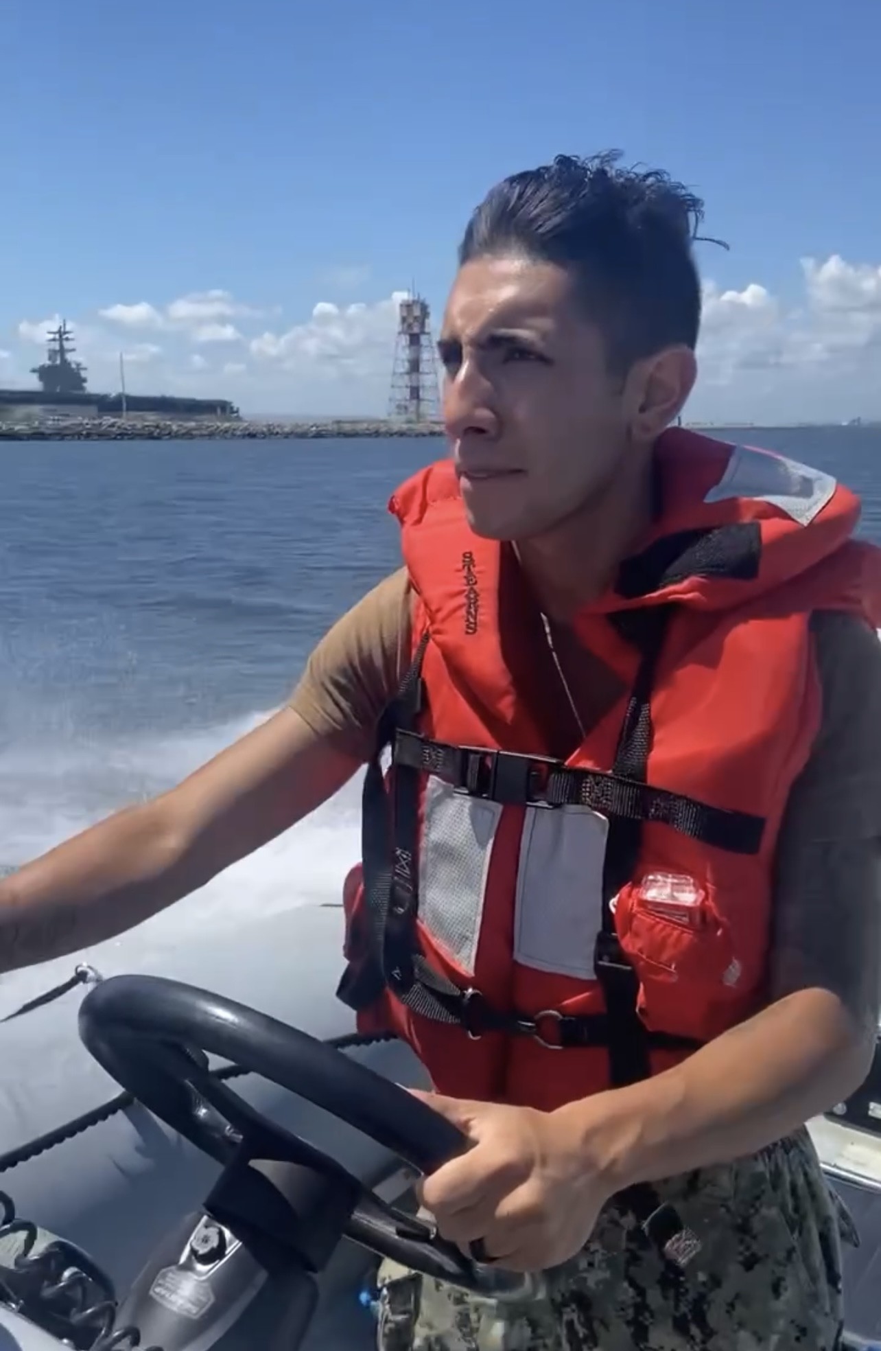 Elijah Reyes driving a boat while he was in the Navy.