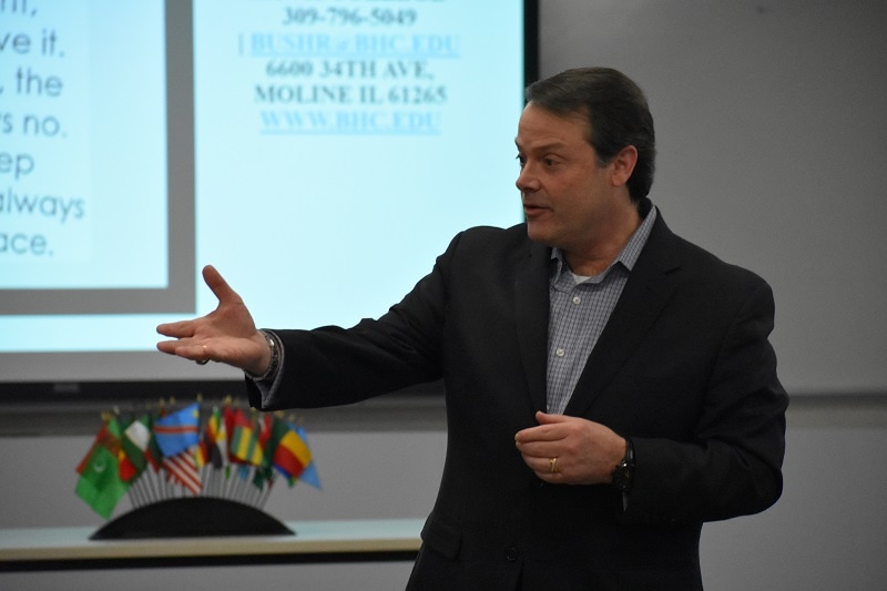 man in suit gesturing while speaking