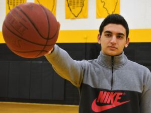 college basketball player holds a basketball out