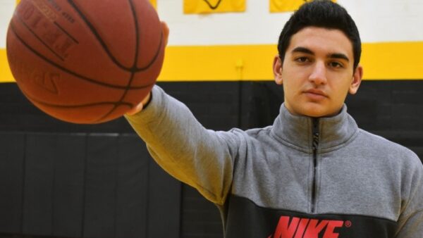 college basketball player holds a basketball out