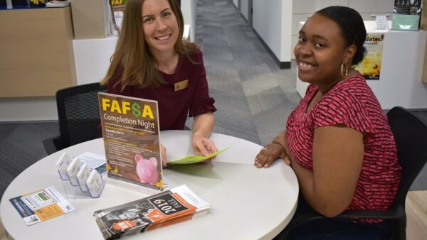 Financial Aid director and student sitting at a table smiling