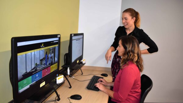 Financial Aid director helping a student sitting at a computer