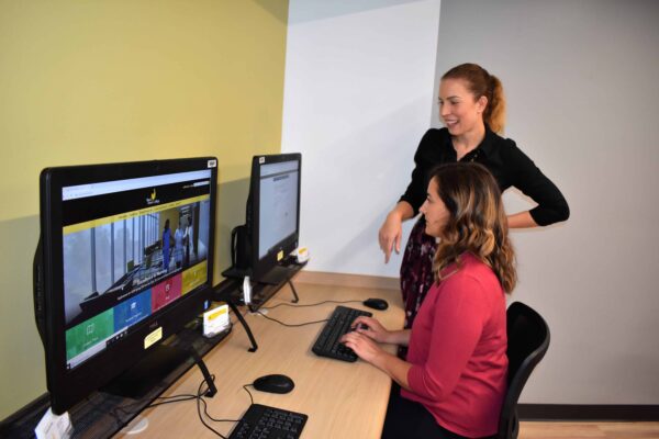 Financial Aid director helping a student sitting at a computer