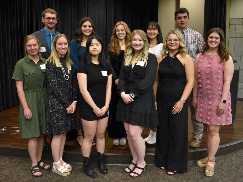 11 students standing and smiling at camera