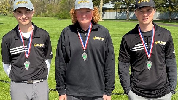 3 golfers wearing medals and smiling at camera