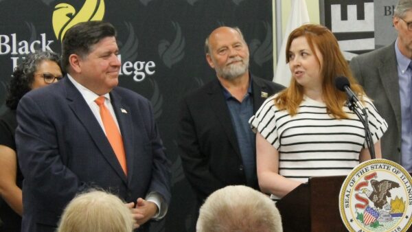 BHC student Lauren Rogan at podium and speaking to IL Gov Pitzker