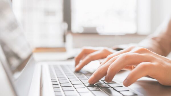 closeup of hands typing on laptop