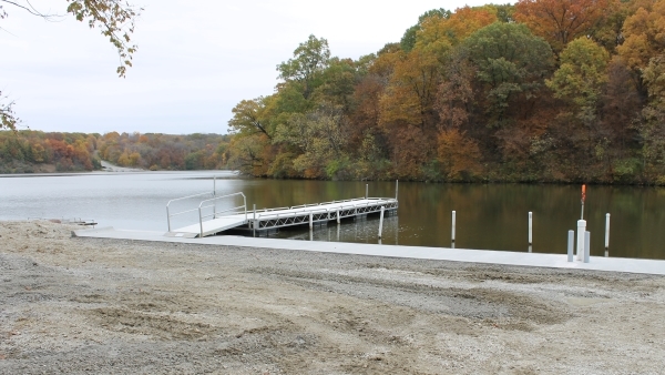 shore, dock and lake with colorful fall trees in background