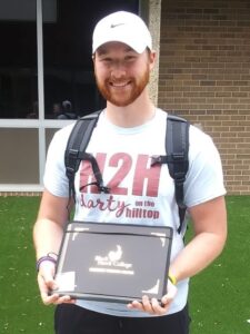 smiling grad outside holding certificate