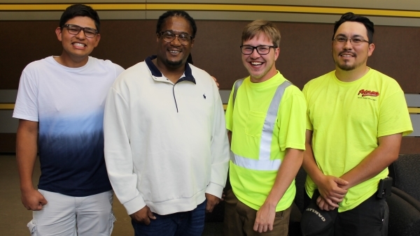 4 people standing & smiling at camera