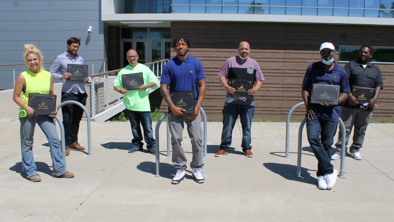 7 people lined up on sidewalk outside building