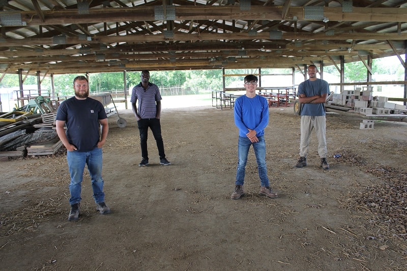 four men standing in a pavilion